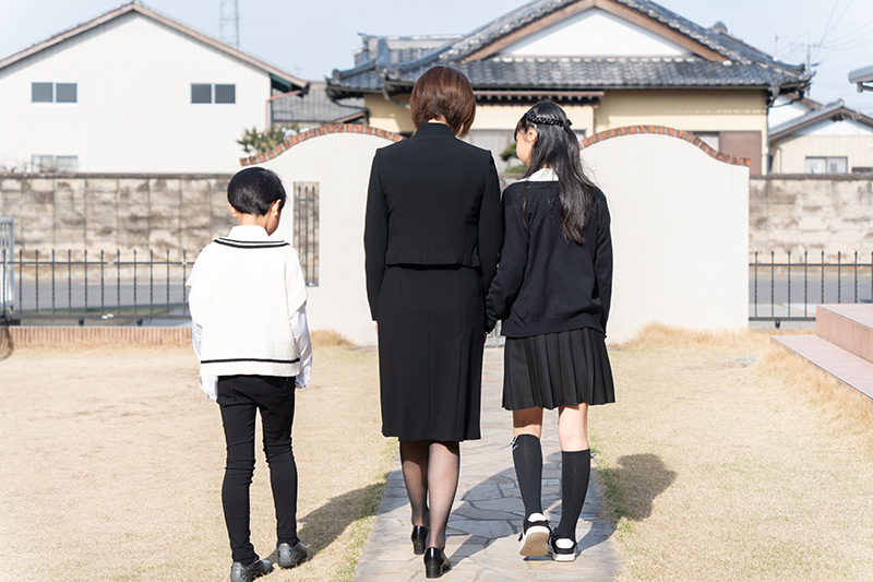お葬式に向かう喪服の家族